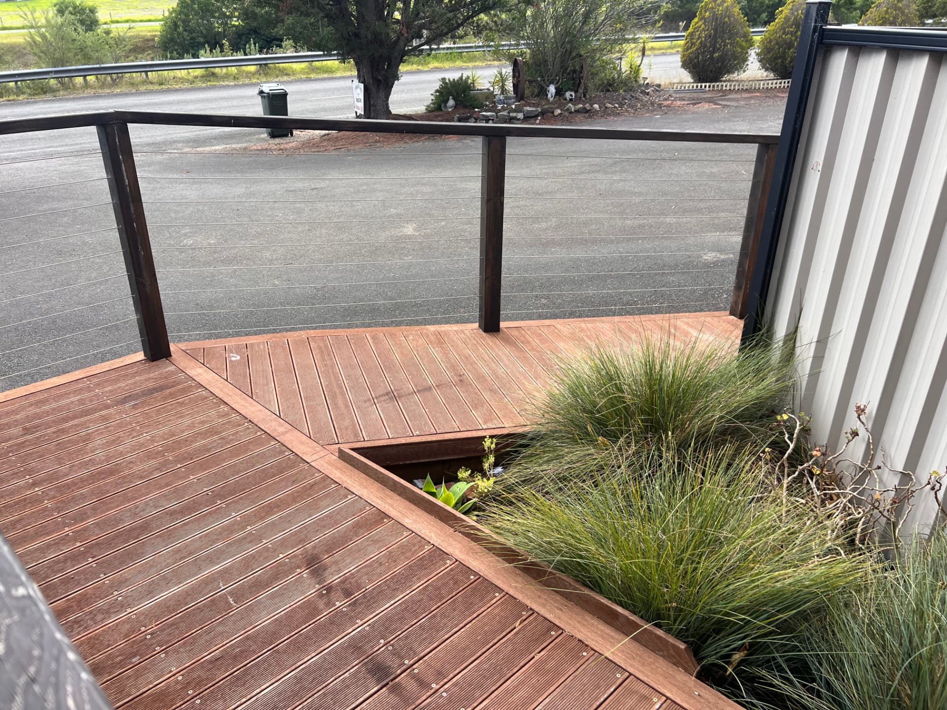 Front deck with wire balustrade and native grasses at Longhorn Ranch Apartments