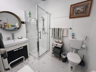 Bathroom with corner shower, vanity and round mirror - 3 Bedroom Cottage, Longhorn Ranch Apartments Orbost