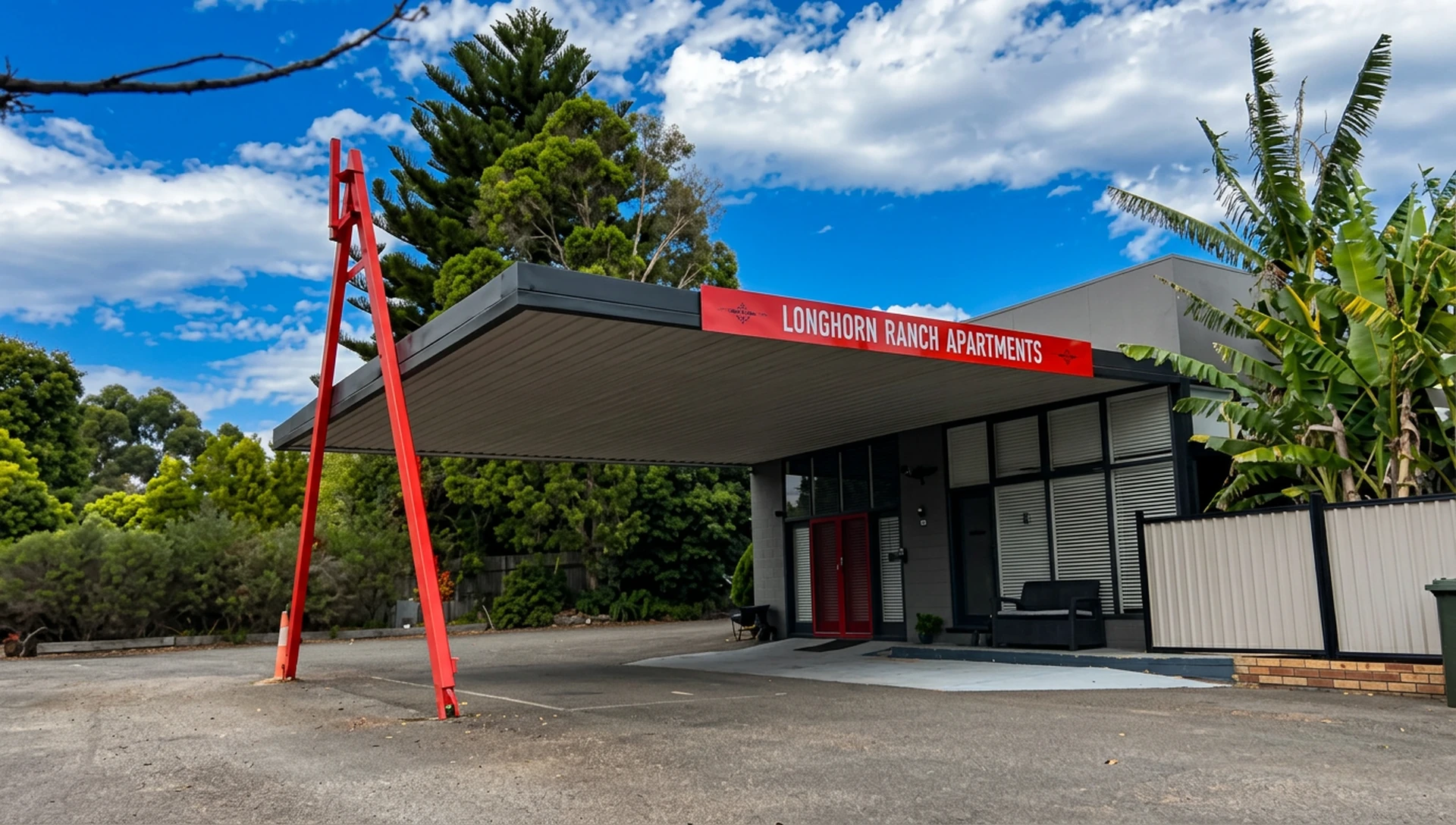 Entrance to Longhorn Ranch Apartments, 1 Irvines Road Orbost, showing the red signage and undercover parking
