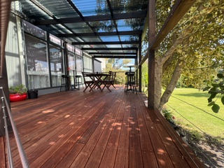 Covered rear deck with outdoor dining and bar setting overlooking the lawn - 5 Bedroom Apartment, Longhorn Ranch Apartments Orbost