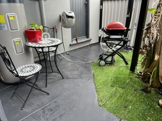 Enclosed courtyard with gas Weber BBQ and small outdoor setting - Studio Apartment, Longhorn Ranch Apartments Orbost