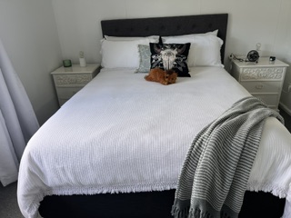 Queen bedroom with white bedlinen, bedside tables and throw rug - 3 Bedroom Cottage, Longhorn Ranch Apartments Orbost