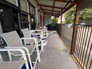 Fully fenced verandah with outdoor chairs and tables looking to the garden - 3 Bedroom Cottage, Longhorn Ranch Apartments Orbost